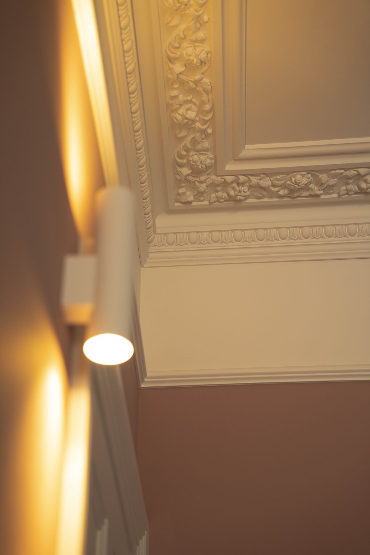 Ornate cornice detail with wall-mounted lighting