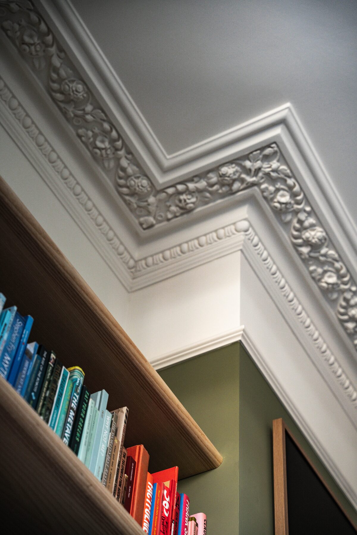 Restored ornamental ceiling cornice above timber shelving