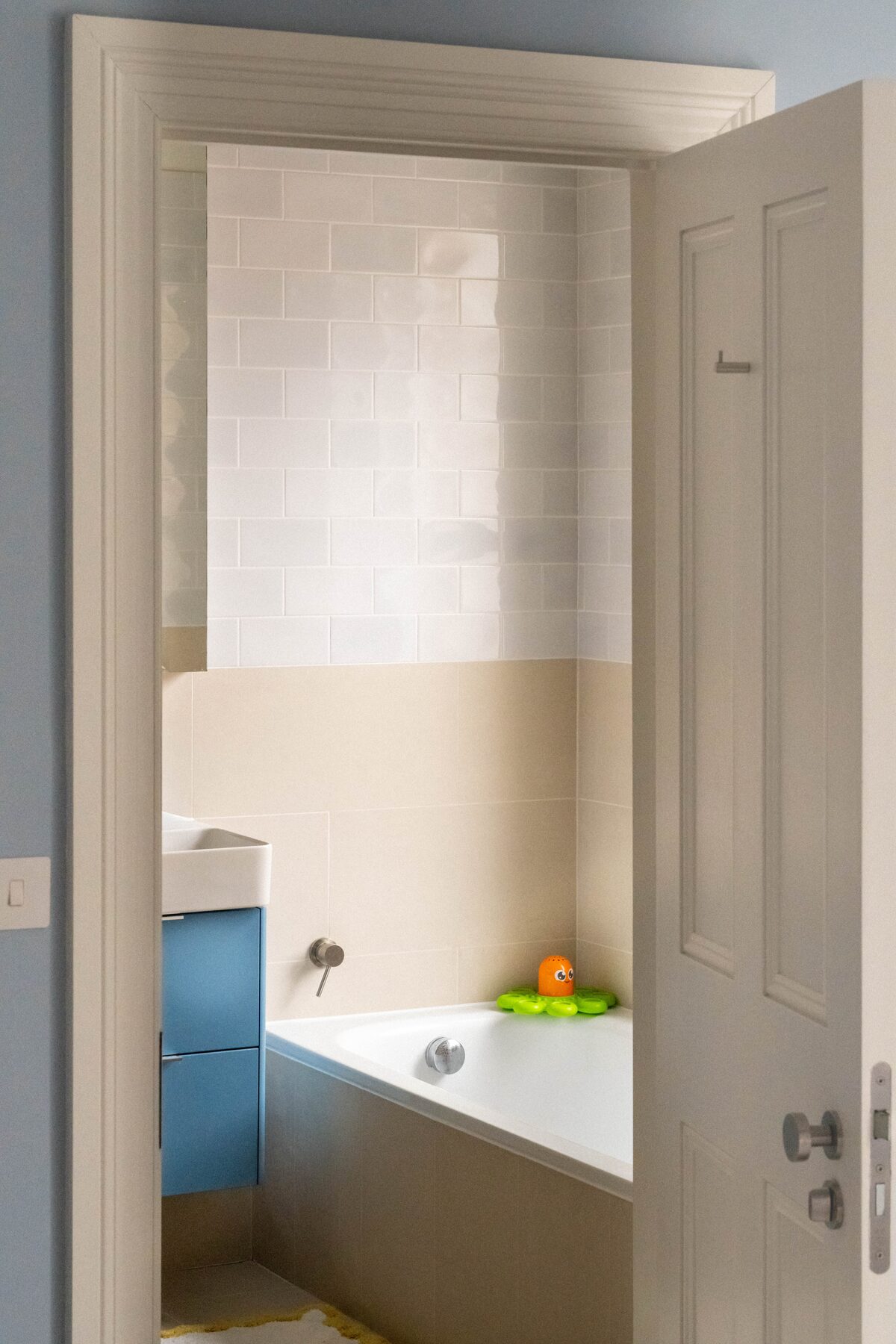 Doorway view to family bathroom with blue vanity