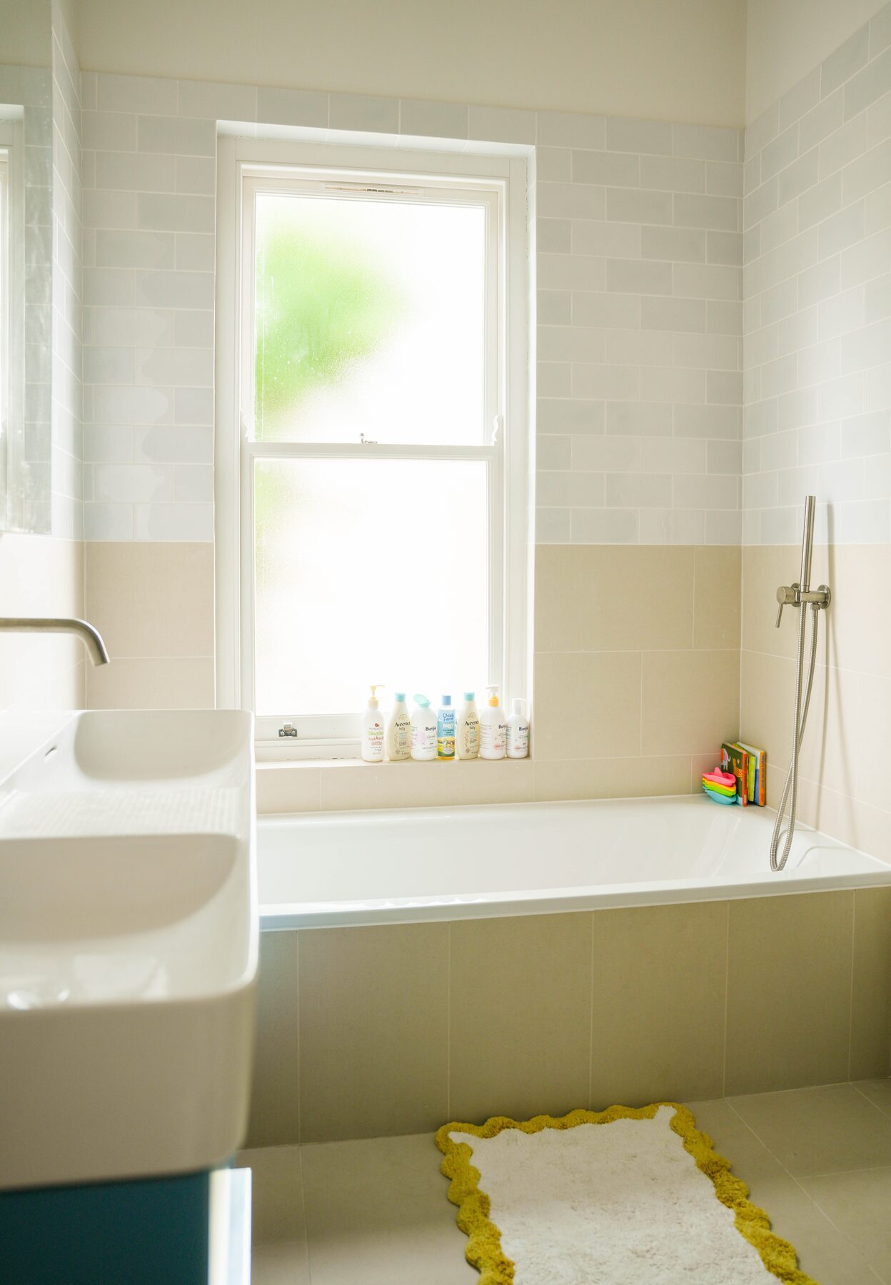 Bathroom with two-tone tiling and bathtub