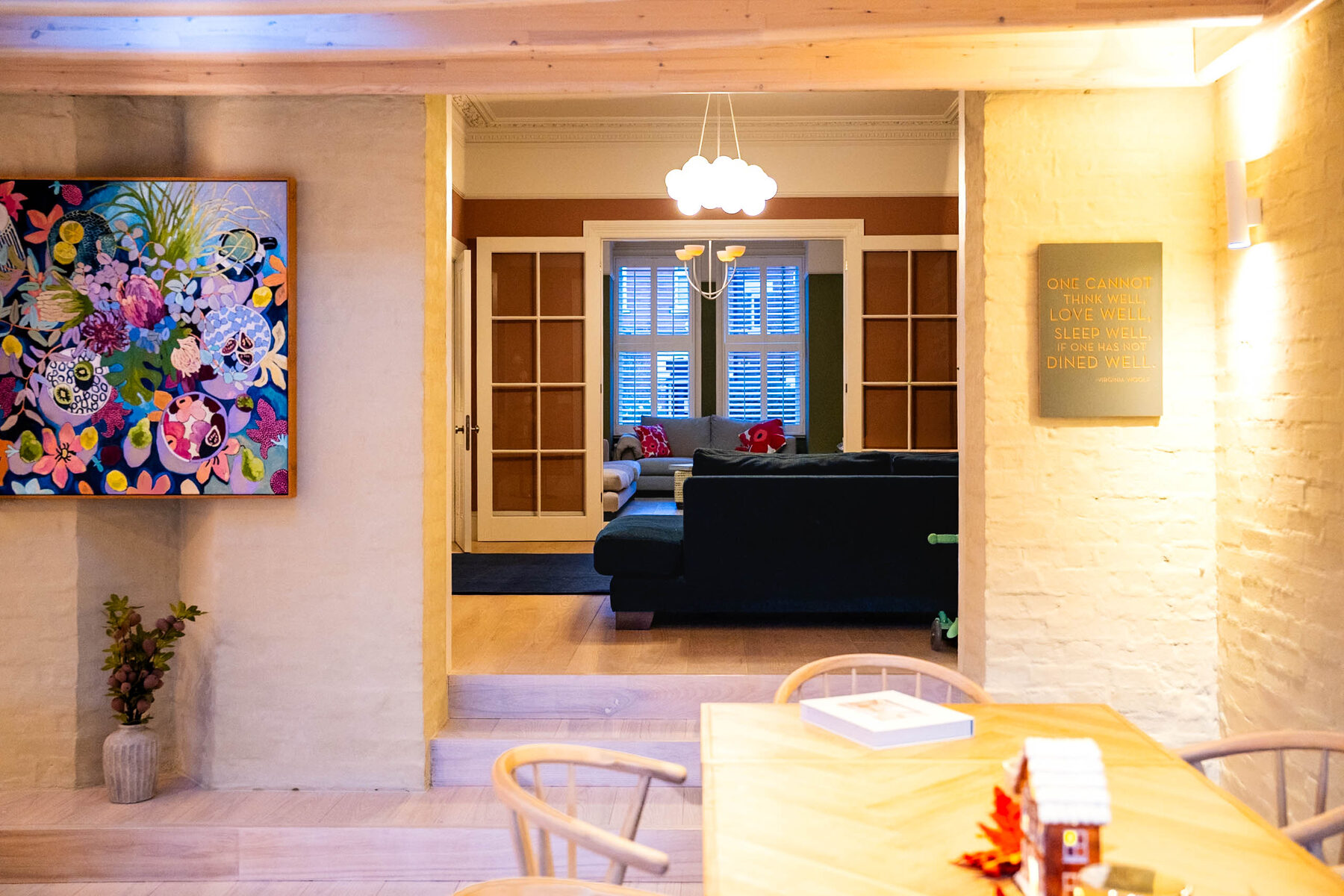 Dining room looking through to living room with colourful artwork